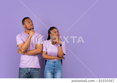 Pensive black couple looking aside at free copy space, thinking Pensive black couple looking aside at free copy space, thinking 83350367