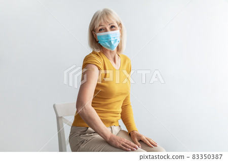 Mature Lady In Face Mask Showing Vaccinated Arm, Gray Background 83350387