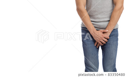 Cropped millennial european muscular male suffering from groin pain, presses hand to crotch Cropped millennial european muscular male suffering from groin pain, presses hand to crotch 83350480