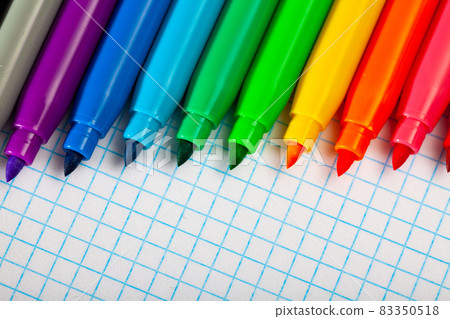 Many various felt tip pens on checkered sheet of paper 83350518