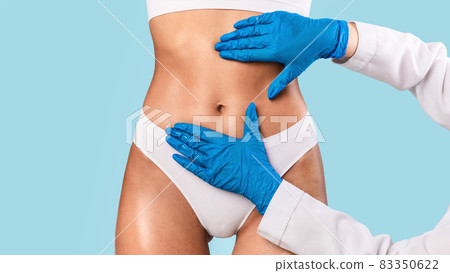 Woman having lipolysis treatment at beauty salon, doctor examining belly Woman having lipolysis treatment at beauty salon, doctor examining belly 83350622