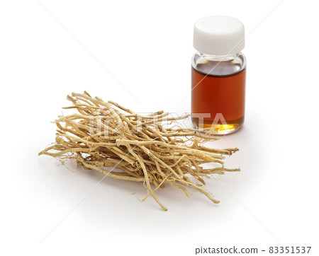 A vial of dried vetiver root and vetiver essential oil A vial of dried vetiver root and vetiver essential oil 83351537