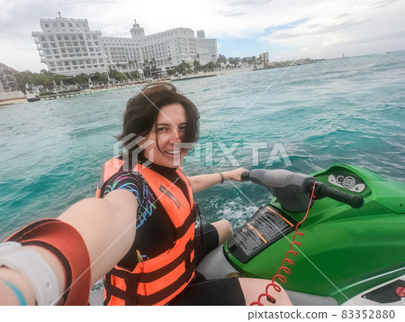 Woman making selfie photo while riding jet ski on Caribbean sea resort 83352880