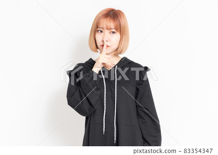 Young woman making a secret gesture 83354347