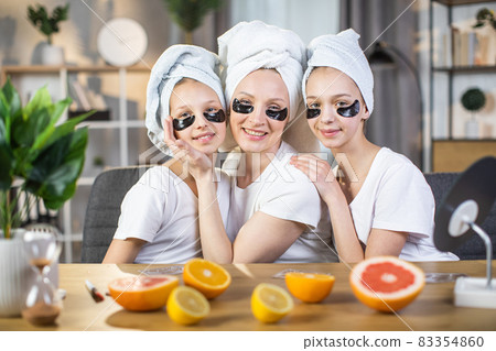 Woman with daughters wearing collagen patches under eyes Woman with daughters wearing collagen patches under eyes 83354860