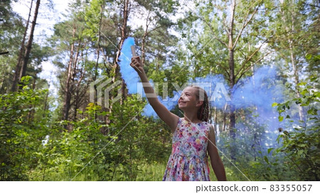 A teenage girl with blue smoke walks in the forest. A teenage girl with blue smoke walks in the forest. 83355057