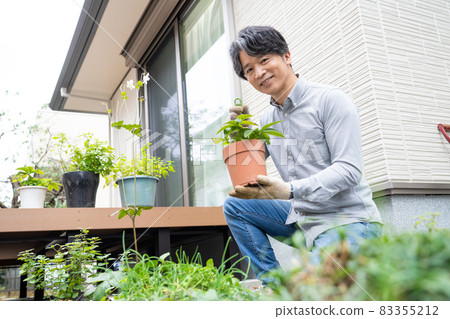 Middle man gardening in his garden 83355212