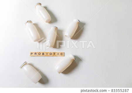 Small bottles with probiotics and prebiotics dairy drink on white background. Production with biologically active additives. Fermentation and diet healthy food. Bio yogurt with useful microorganisms. Small bottles with probiotics and prebiotics dairy drink on white background. Production with biologically active additives. Fermentation and diet healthy food. Bio yogurt with useful microorganisms. 83355287