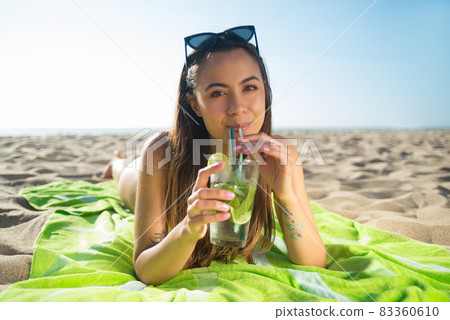 Cute young woman drinking cocktail Cute young woman drinking cocktail 83360610