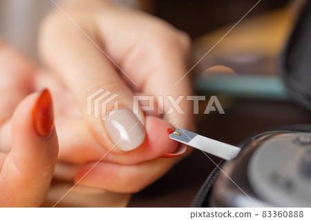Woman testing for high blood sugar. Woman holding device for measuring blood sugar. Woman testing for high blood sugar. Woman holding device for measuring blood sugar. 83360888
