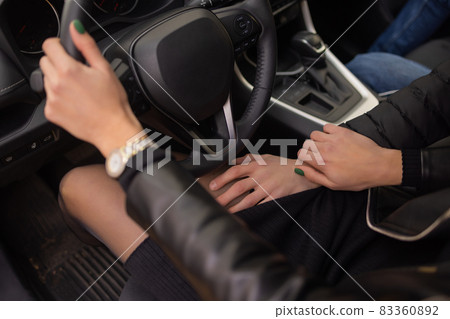 woman's hands holding on to the wheel of a new car in the showroom. woman's hands holding on to the wheel of a new car in the showroom. 83360892