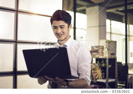 young asian business man entrepreneur checking information or data using laptop computer in office 83361601