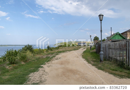 Dirt road on the street with lanterns and woode fences near the Volga River in Sviyazhsk, Russia Dirt road on the street with lanterns and woode fences near the Volga River in Sviyazhsk, Russia 83362720
