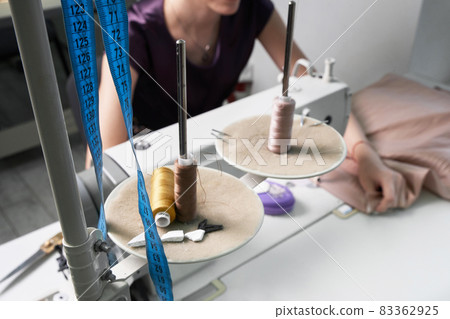 Woman using sewing machine in tailor studio, modern atelier shop Woman using sewing machine in tailor studio, modern atelier shop 83362925