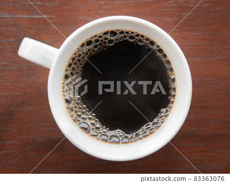 Hot Americano coffee in a mug on a wooden board. Hot Americano coffee in a mug on a wooden board. 83363076