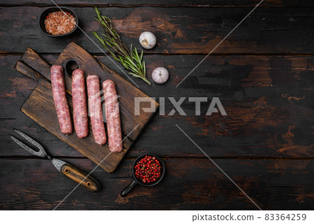 Fresh homemade sausages, on old dark wooden table background, top view flat lay, with copy space for text 83364259