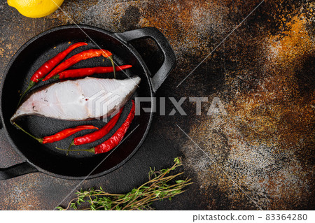 Fresh steak raw fish halibut, with ingredients and rosemary herbs, on old dark rustic table background, top view flat lay, with copy space for text 83364280