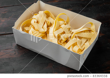 Italian pasta pappardelle, on old dark wooden table background 83364338
