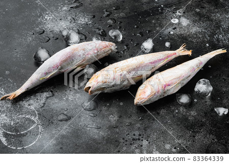 Frozen red mullet or barabulka raw fish, on black dark stone table background , with copy space for text 83364339