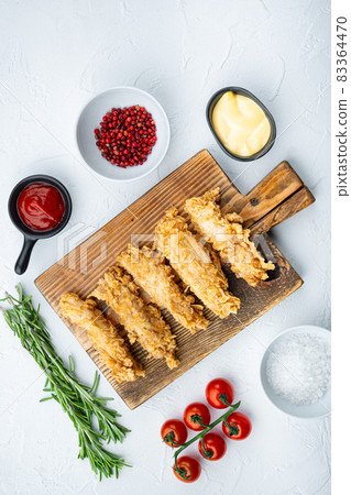 Fried crispy chicken stripes on white background, top view Fried crispy chicken stripes on white background, top view 83364470