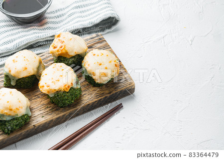 Baked sushi roll with shrimp and masago caviar cap. Traditional sushi restaurant dish, on white stone background , with copyspace and space for text Baked sushi roll with shrimp and masago caviar cap. Traditional sushi restaurant dish, on white stone background , with copyspace and space for text 83364479