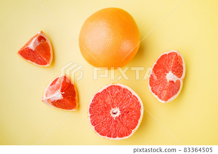 Grapefruit citrus fruit with half , on yellow textured summer background, top view flat lay Grapefruit citrus fruit with half , on yellow textured summer background, top view flat lay 83364505