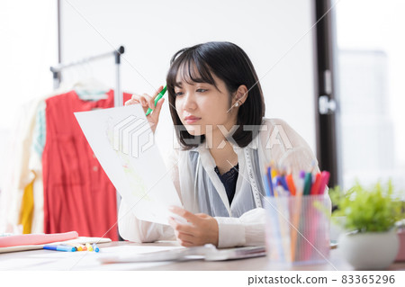 Young woman thinking about clothing design Young woman thinking about clothing design 83365296