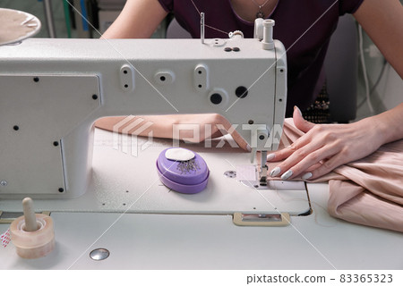 dressmaker using sewing machine in tailor studio, modern atelier shop 83365323