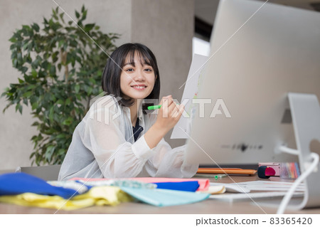 Young woman thinking about clothing design 83365420