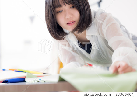 Fashion college student, a young woman sewing clothes Fashion college student, a young woman sewing clothes 83366404