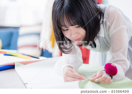Fashion college student, a young woman sewing clothes 83366409