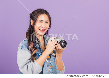 young woman smiling excited wear denims holding vintage photo camera young woman smiling excited wear denims holding vintage photo camera 83366475