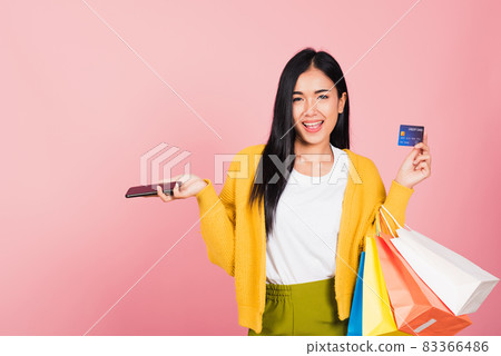 woman shopper smiling standing excited holding online shopping bags colorful and credit card woman shopper smiling standing excited holding online shopping bags colorful and credit card 83366486