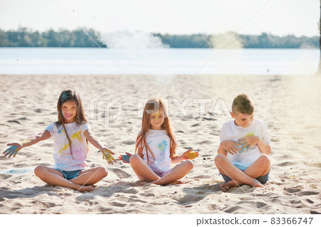 kids having fun by playing with colored powder 83366747