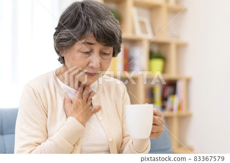 Senior woman who has difficulty swallowing dysphagia Senior woman who has difficulty swallowing dysphagia 83367579