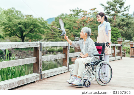 公園散步的老人和醫務人員（動物治療） 83367805