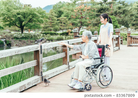 Elderly people taking a walk in the park and medical staff (animal therapy) Elderly people taking a walk in the park and medical staff (animal therapy) 83367809