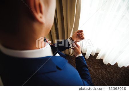 Elegant businessman dressed clock before meeting with partners. 83368018