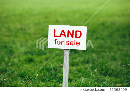 land for sale sign against trimmed lawn background 83368409