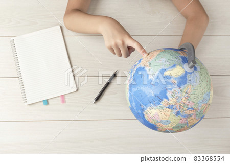 A child studying maps. A child learning about abroad. Geography, travel, maps, society, language, study, etc. 83368554