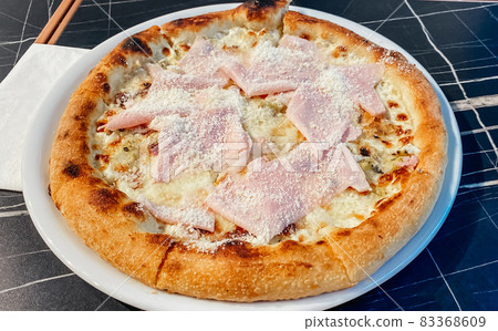 Close-up on a restaurant table pizza with prosciutto cotto and taleggio cheese Close-up on a restaurant table pizza with prosciutto cotto and taleggio cheese 83368609