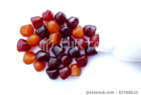 Group of red, orange and purple multivitamin gummies with the bottle isolated on white background. Group of red, orange and purple multivitamin gummies with the bottle isolated on white background. 83368610