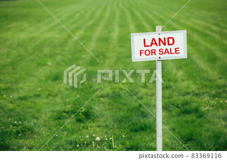 land for sale sign against trimmed lawn background 83369116