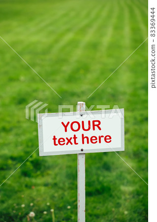 your text here sign against green lawn background 83369444