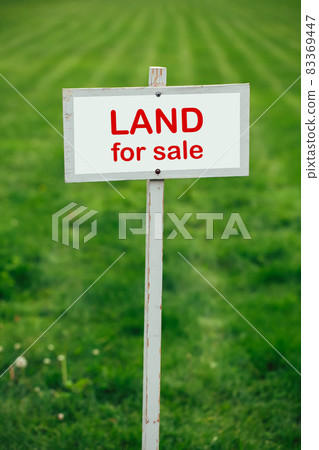 land for sale sign against trimmed lawn background 83369447