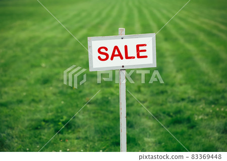 sale sign against trimmed lawn background 83369448