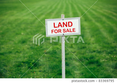 land for sale sign against trimmed lawn background 83369795