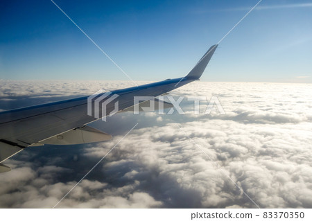 A cityscape with a faint view of clouds and blue sky overlooking from an airplane A cityscape with a faint view of clouds and blue sky overlooking from an airplane 83370350