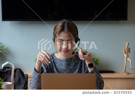 Shot smiling asian woman freelancer wearing headset, communicating with client via video computer call. Millennial pleasant professional female tutor giving online language class 83370593
