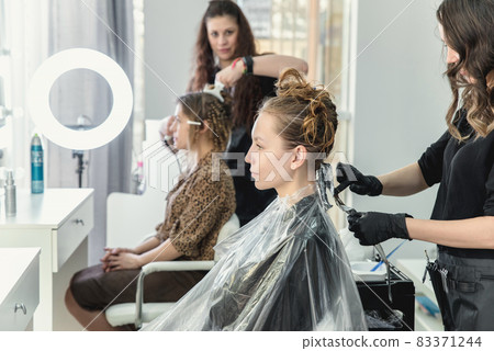 woman having hair foiled while coloring in hair salon 83371244
